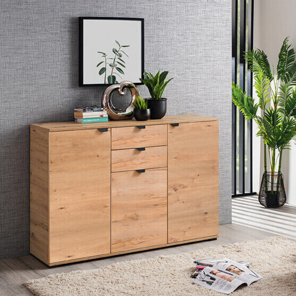 Credenza in rovere chiaro inserita in un ambiente sofisticato con parete grigia testurizzata e una grande pianta ornamentale.