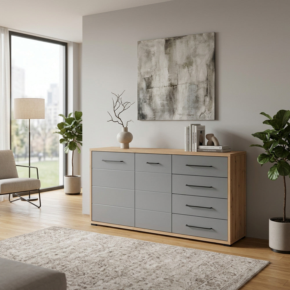 Credenza Lisabon in rovere artigiano e grigio grafite ambientata in un living luminoso con piante decorative.
