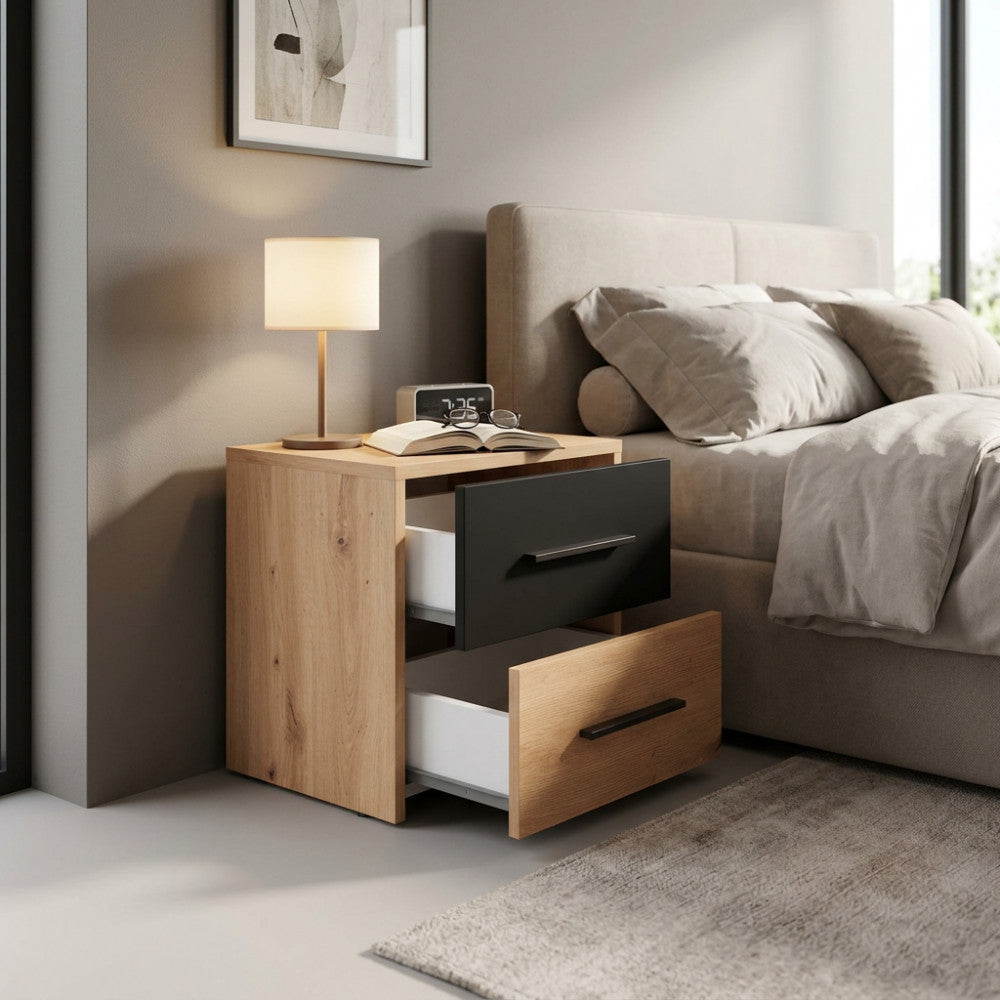 Comodino Varadero in rovere chiaro ambientato in una camera da letto moderna con lampada accesa.