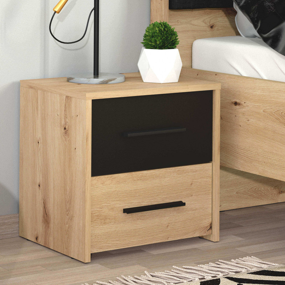 Ambientazione ravvicinata del comodino accanto a un letto, decorato con una piccola pianta e una lampada di design.