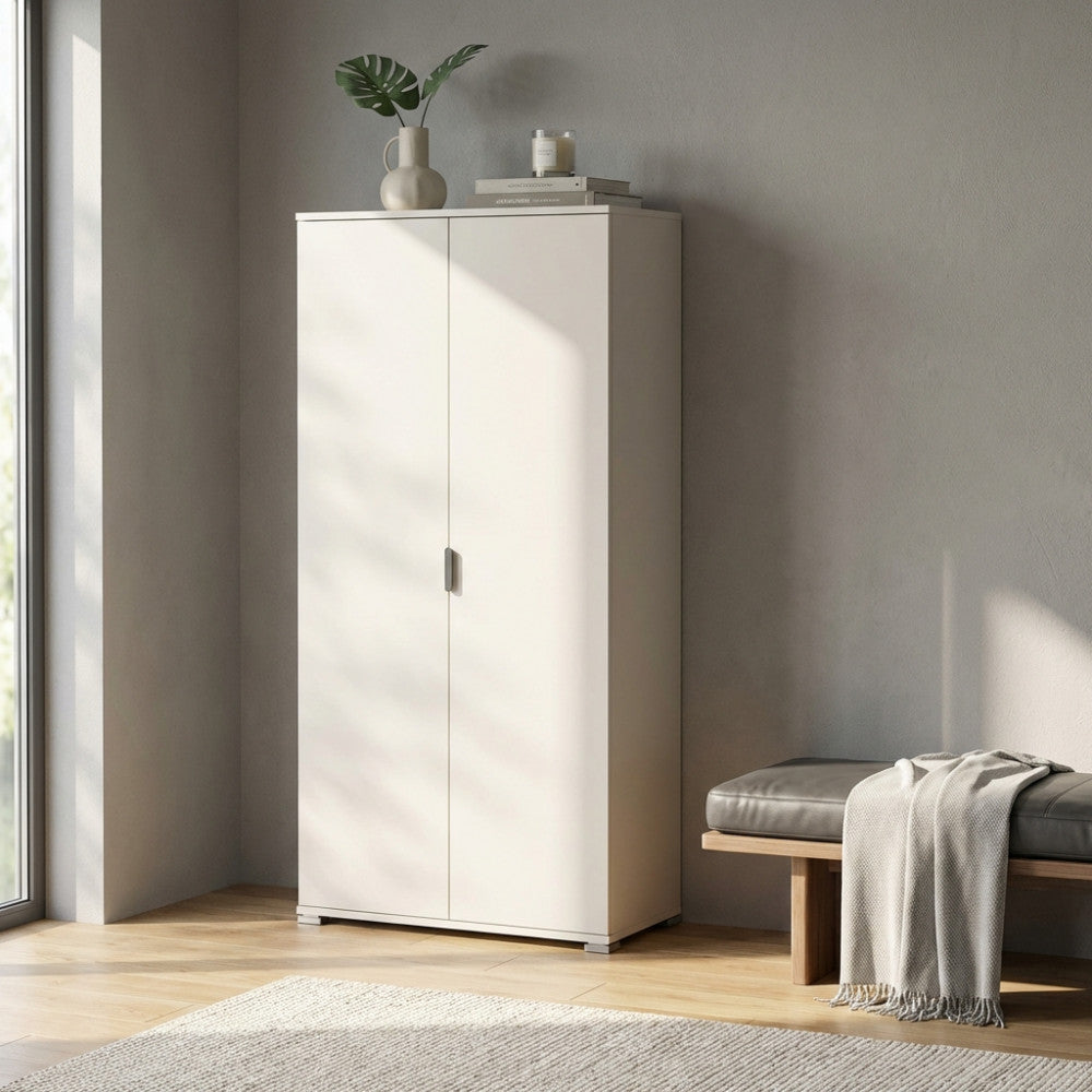 Armadio bianco a due ante inserito in un ingresso minimalista illuminato da luce naturale.