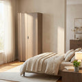 Armadio a due ante in rovere grigio ambientato in una camera da letto luminosa con tessuti in lino.