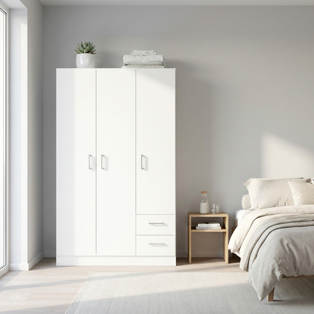 Armadio bianco a tre ante e due cassetti ambientato in una camera da letto luminosa con toni neutri.