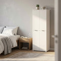 Armadio bianco a quattro ante posizionato in una camera da letto luminosa accanto a un comodino in legno.