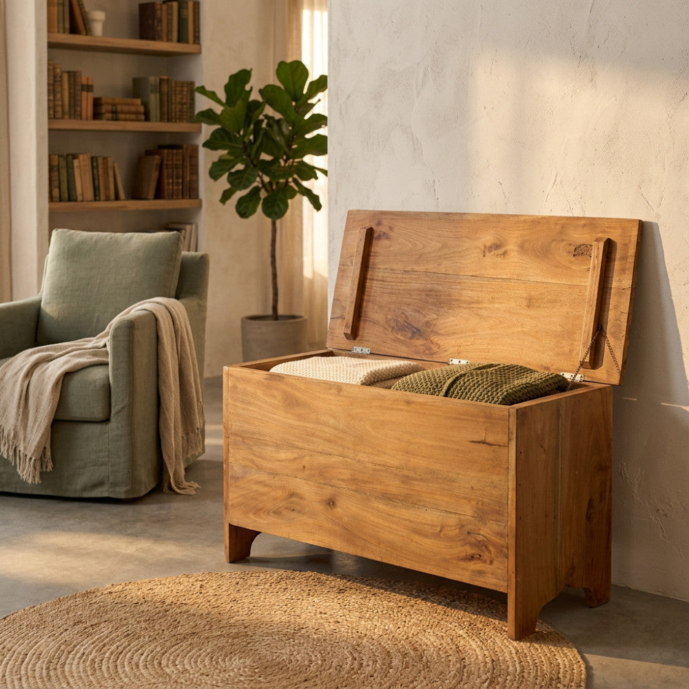 Baule Carlyle aperto in un salotto elegante, contenente coperte e cuscini, mostrando la sua capienza.