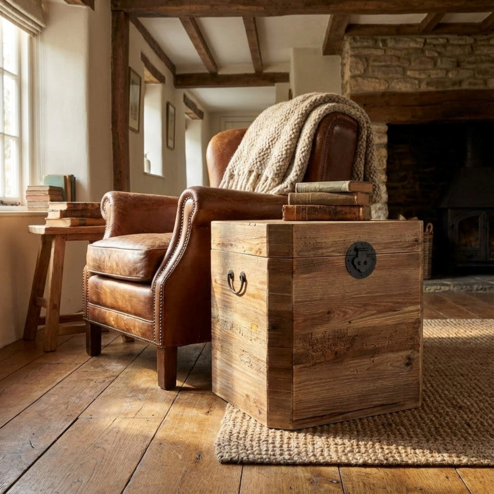 Baule Irving affiancato a una poltrona in pelle vintage in un salotto dal design classico.