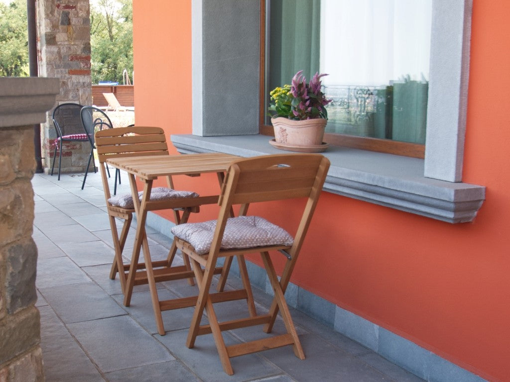 Vista laterale della struttura pieghevole con minuterie metalliche del set bistrot Losa Esterni da vivere