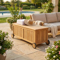 Contenitore BOX NAGOYA in teak posizionato a bordo piscina, decorato con teli bianchi e un cappello di paglia.