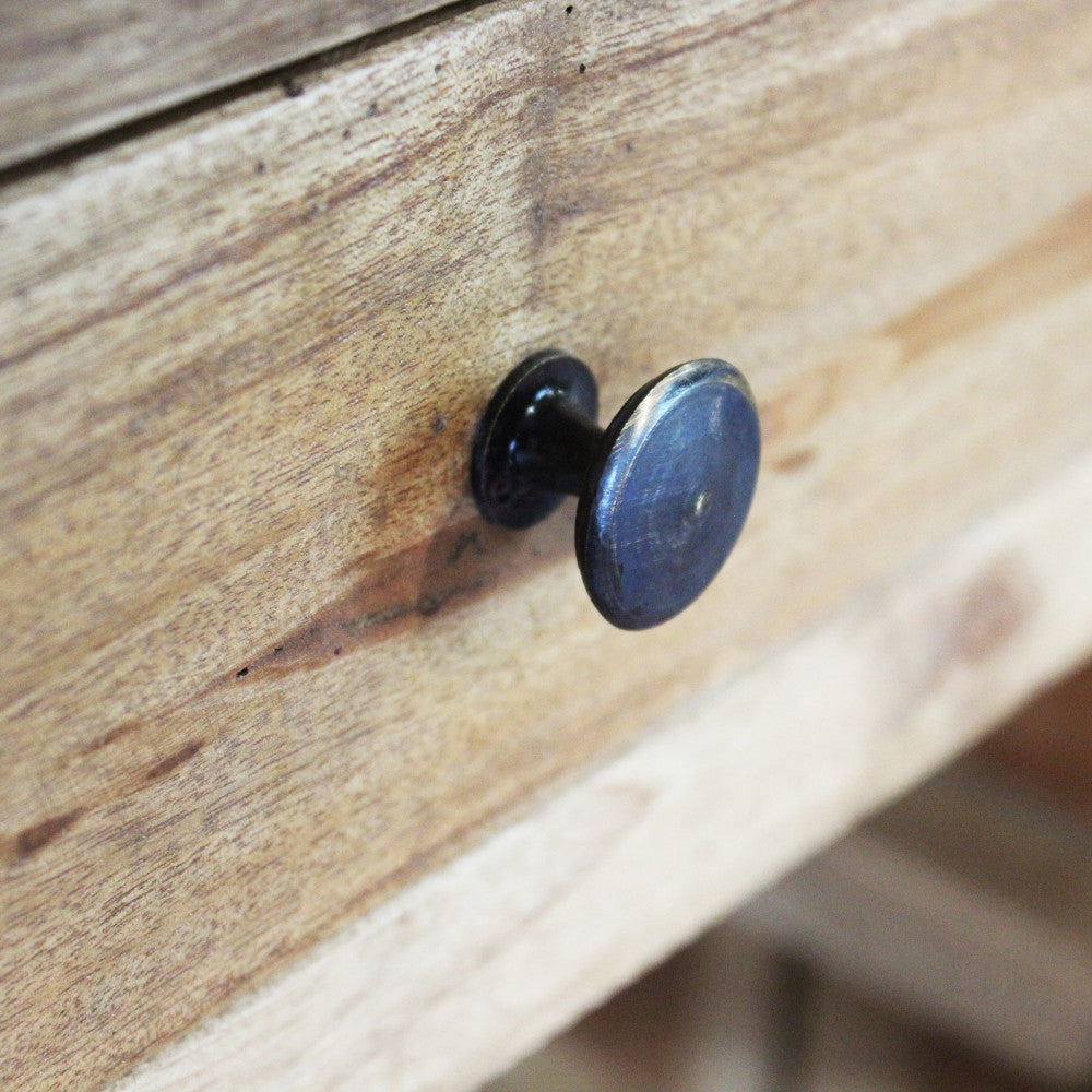 Particolare del pomello in ferro scuro sul cassetto in legno della cantinetta Abigail.