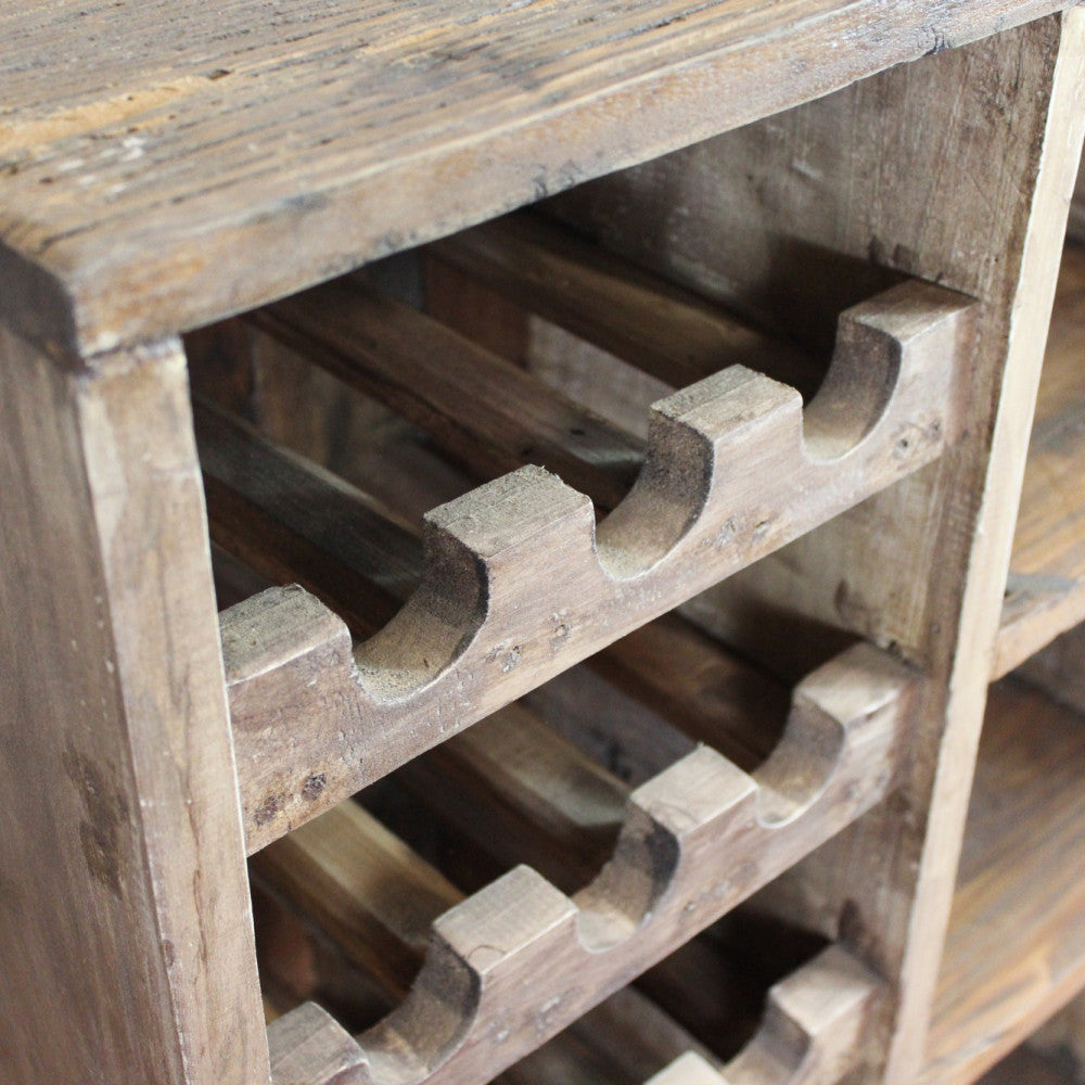 Dettaglio ravvicinato dei ripiani sagomati in legno massello per l'alloggio delle bottiglie.