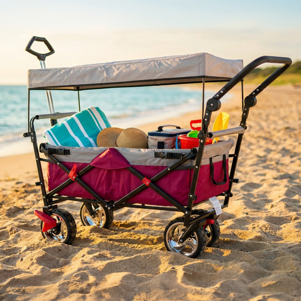 Carrello Baltic in acciaio posizionato su una spiaggia sabbiosa, allestito con asciugamani e accessori estivi sotto la luce naturale.