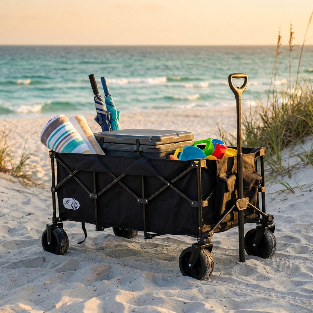 Carrello Black Sea in metallo e poliestere nero, posizionato sulla sabbia con asciugamani e accessori da spiaggia.