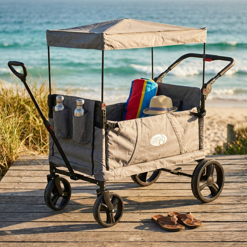 Carrello Caribben grigio chiaro su passerella in legno vista mare, allestito con telo mare e cappello di paglia.