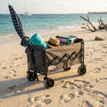 Carrello North in metallo e poliestere grigio scuro sulla spiaggia con ombrellone e teli mare.
