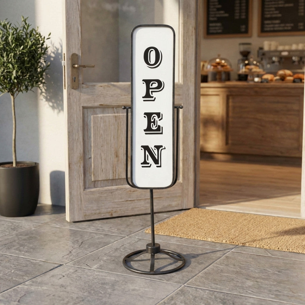 Cartello in acciaio Lazare lato Open posizionato all'esterno di un ingresso rustico.