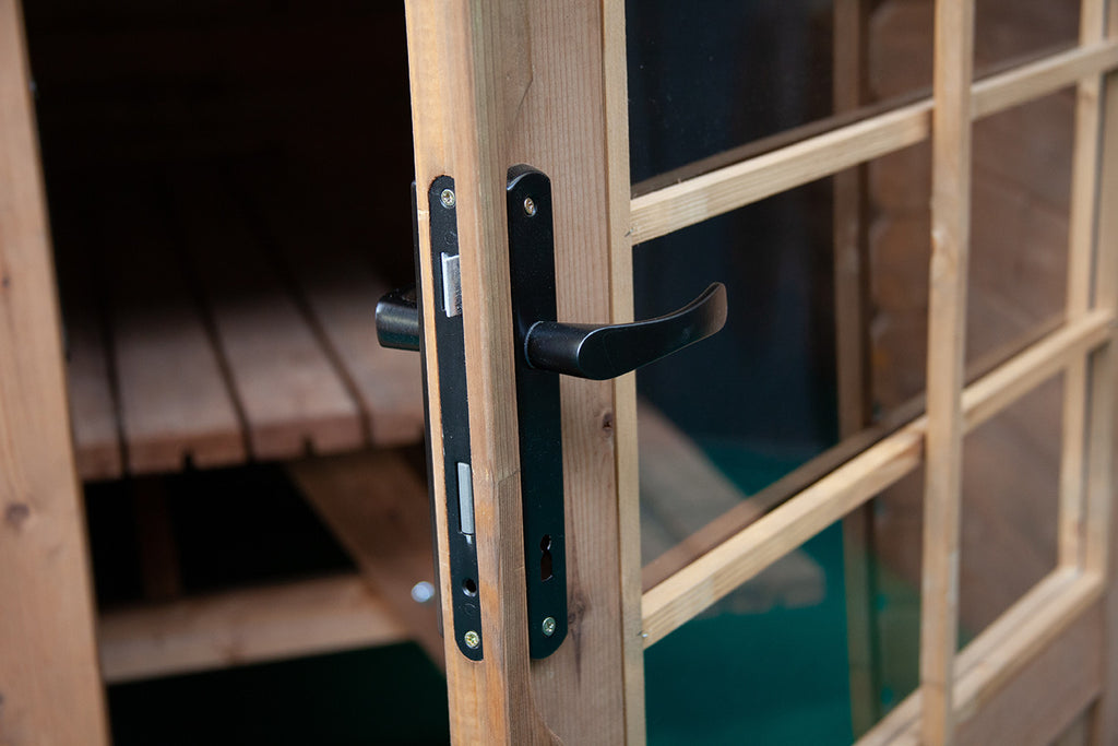 Anta aperta della porta doppia, che mostra la maniglia, i riquadri in vetro e l'interno in legno.