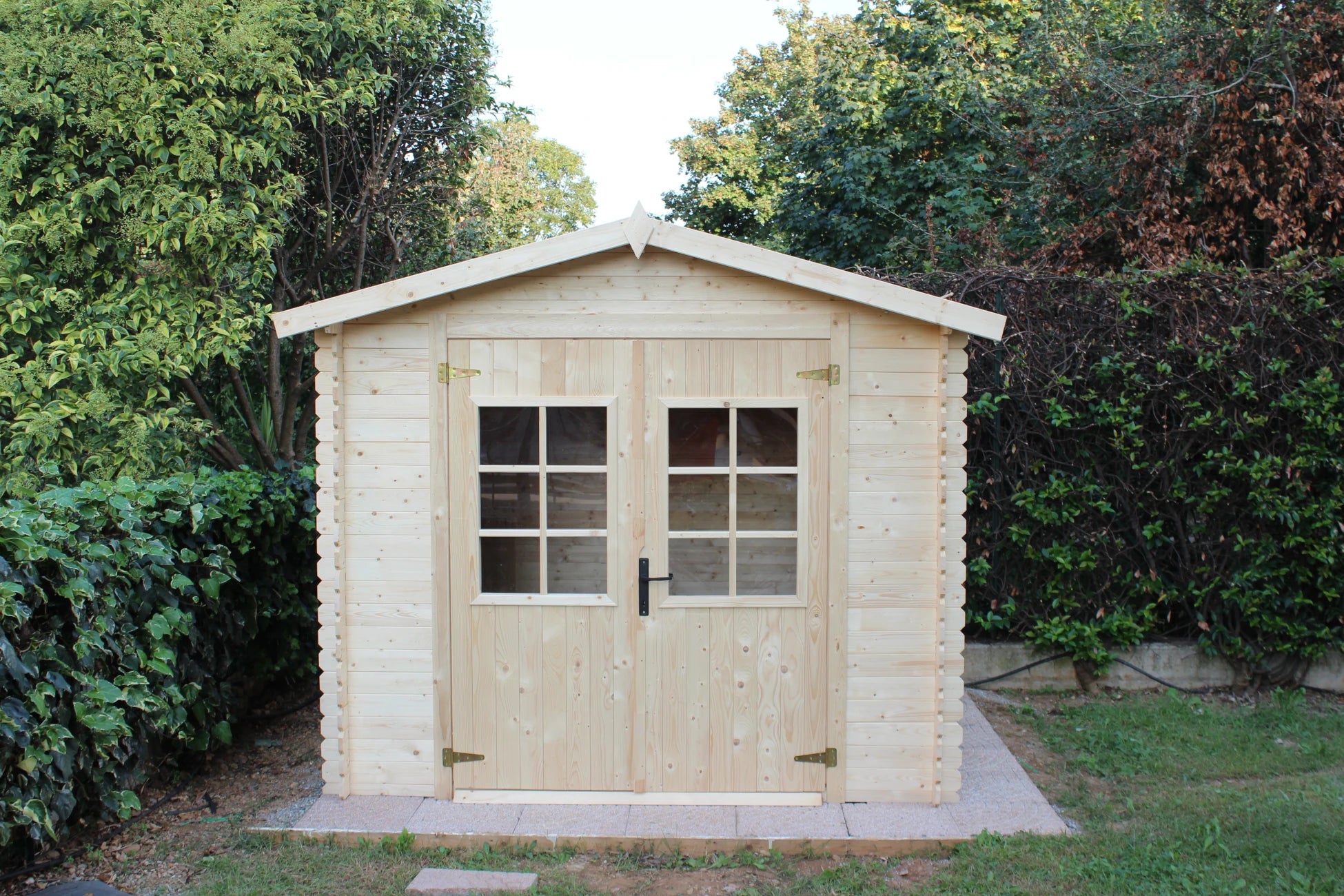 Casetta Sara da giardino 246x200 cm in Abete Grezzo, con doppia porta con serratura e tetto bitumato, vista frontale panoramica