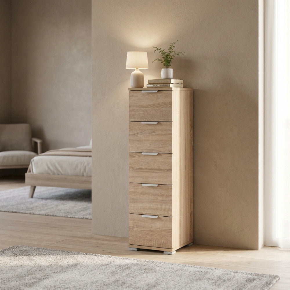 Cassettiera stretta e alta posizionata in una camera da letto dai toni caldi, decorata con lampada e libri.