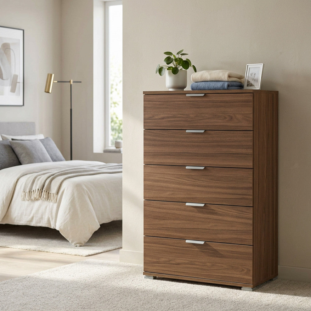 Vista angolare della cassettiera marrone in truciolare bilaminato, affiancata da un letto e dettagli di design.