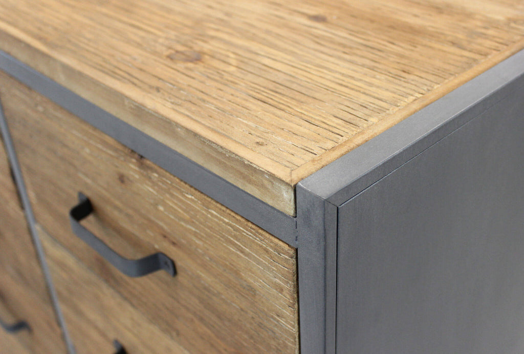 Dettaglio ravvicinato del top in legno materico e del giunto angolare in metallo scuro.