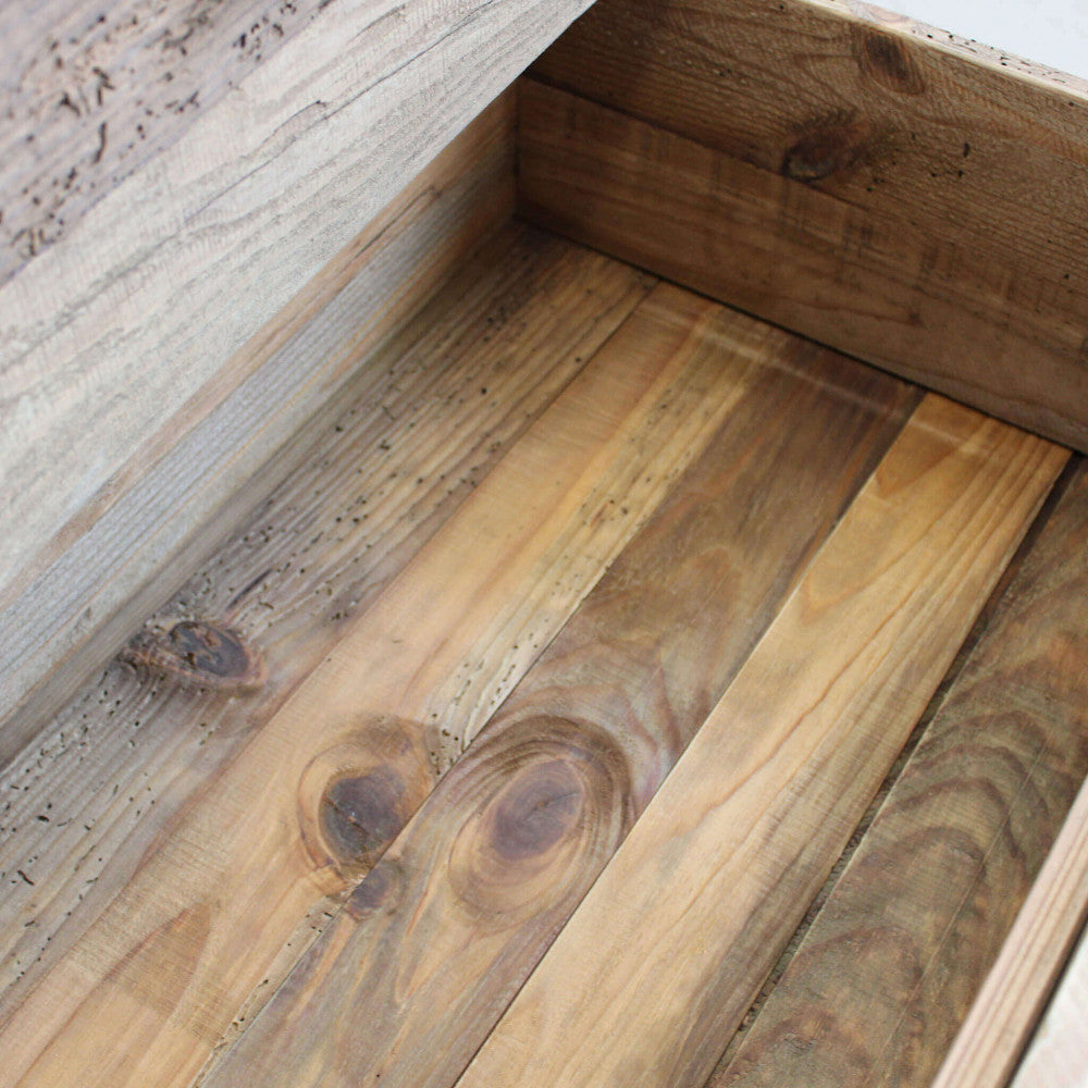 Interno del cassetto in pino riciclato, caratterizzato da nodi naturali e sfumature calde del legno marrone.