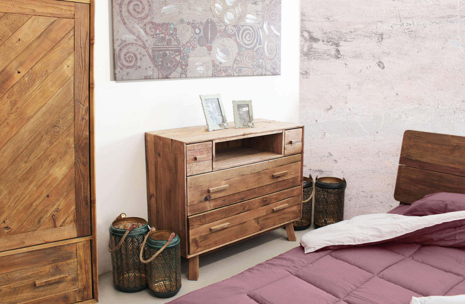 Cassettiera Nelson inserita in una camera da letto dal design eclettico, accanto a un letto con lenzuola bordeaux.