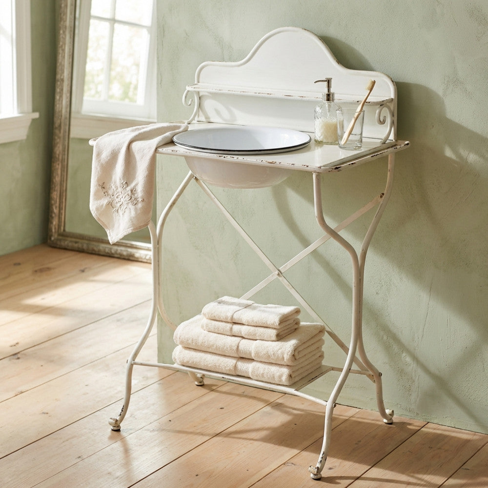 Vista frontale del catino in acciaio bianco stile industriale, allestito con asciugamani in spugna e accessori da bagno su pavimento in legno.