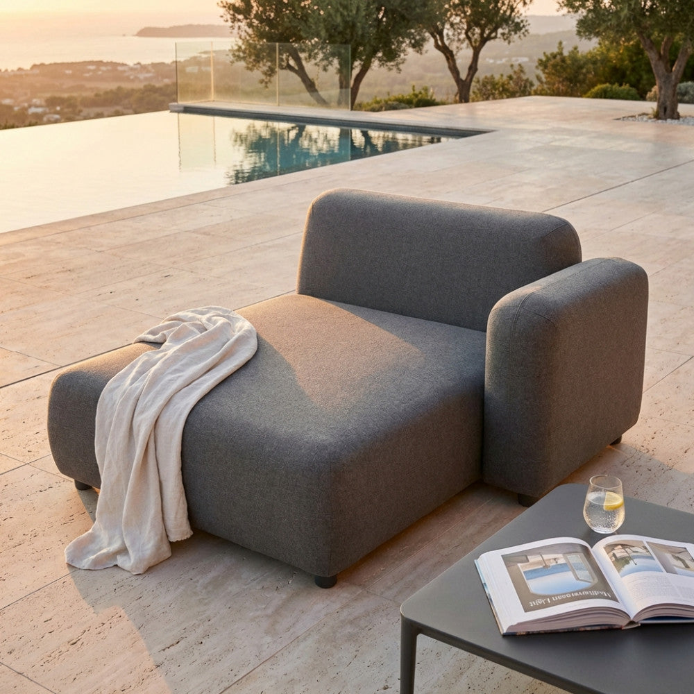 Chaise longue Tucumã in alluminio grigio scuro a bordo piscina al tramonto.
