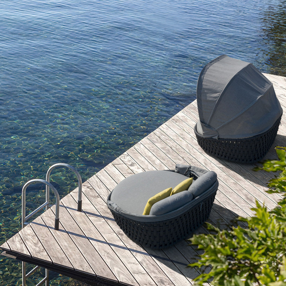 Due conchiglioni Camanã posizionati su un molo in legno vicino all'acqua cristallina.