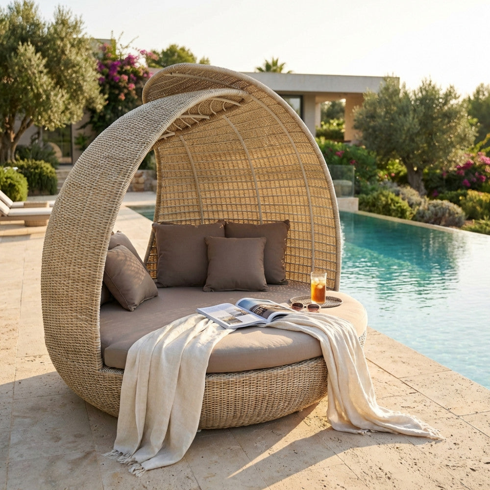Vista laterale del conchiglione da esterno Palma in wicker intrecciato, situato su una pavimentazione in pietra chiara vicino a una piscina.