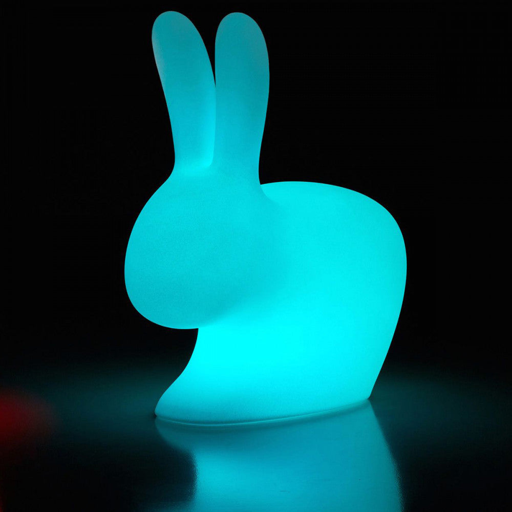 Lampada coniglietto luminoso azzurro che spicca su uno sfondo scuro ed elegante.