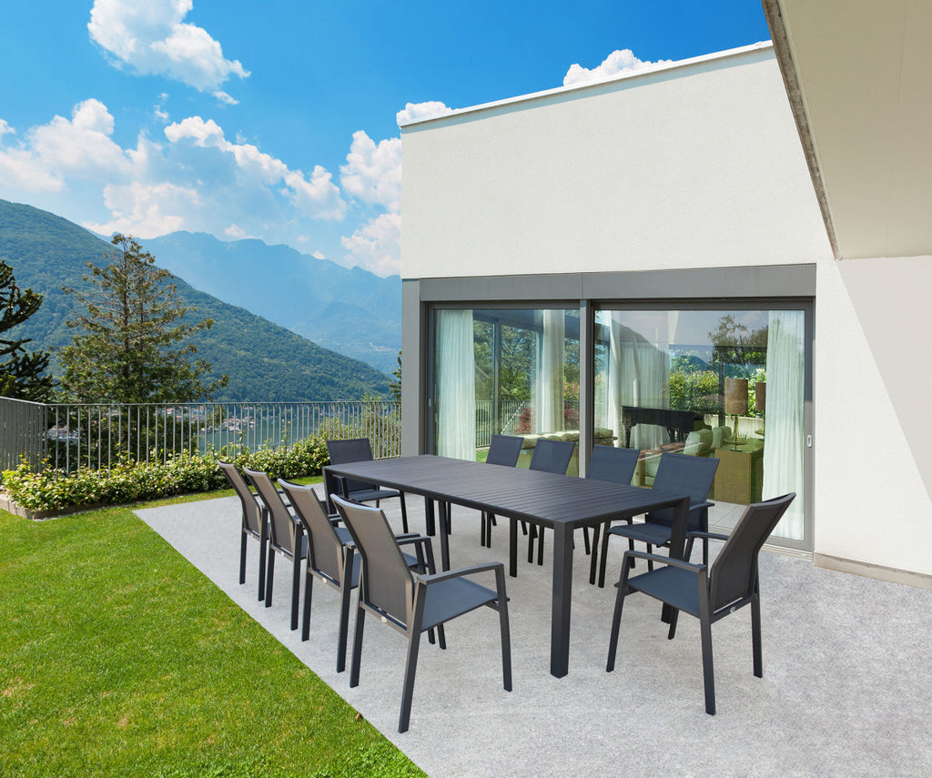 Tavolo consolle esteso circondato da sedie abbinate in un patio moderno con vista panoramica sul lago.