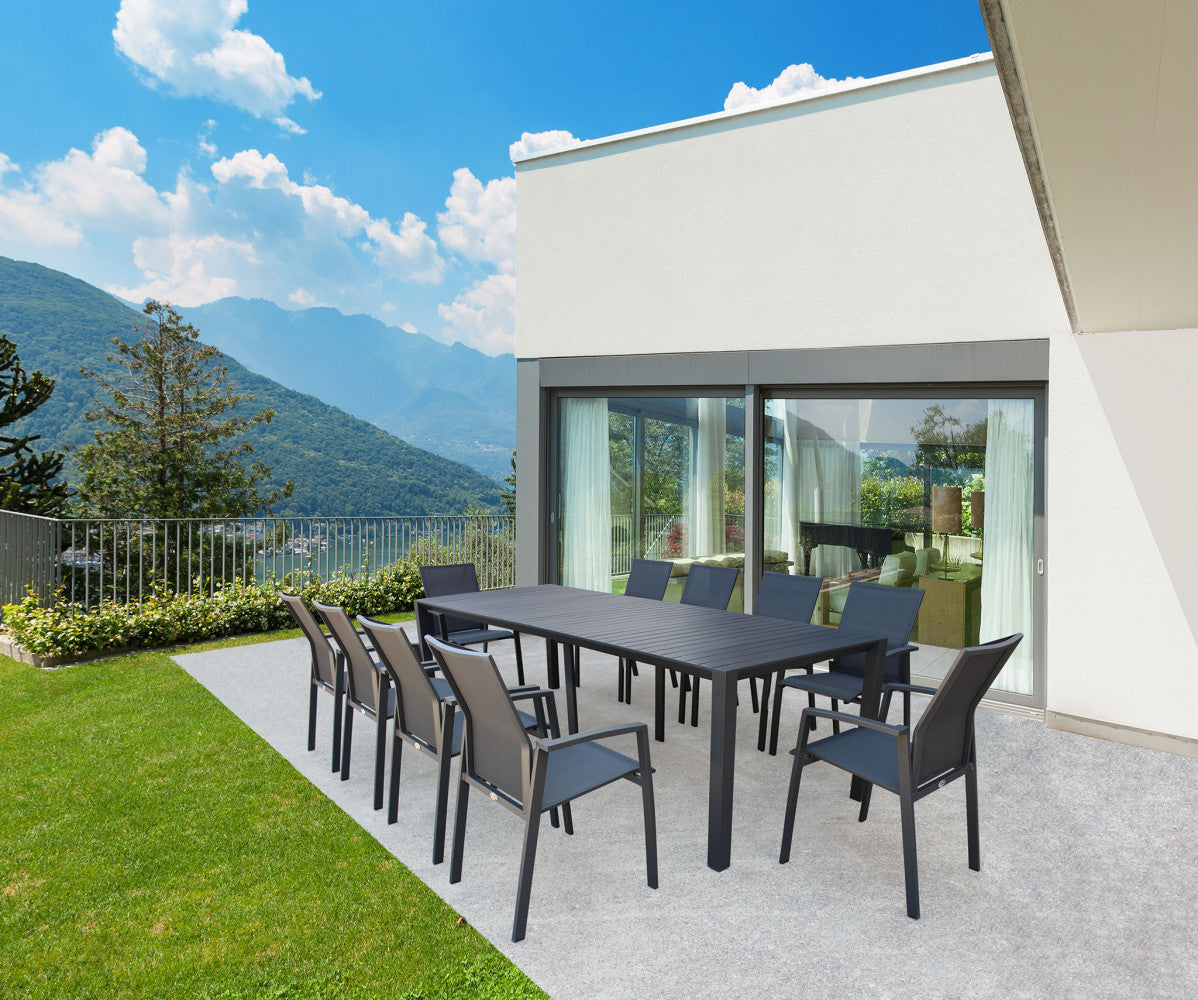 Tavolo consolle esteso circondato da sedie abbinate in un patio moderno con vista panoramica sul lago.