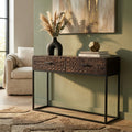 Consolle DALY in legno intagliato e metallo marrone, ambientata in un salotto dal design industrial con vaso decorativo.