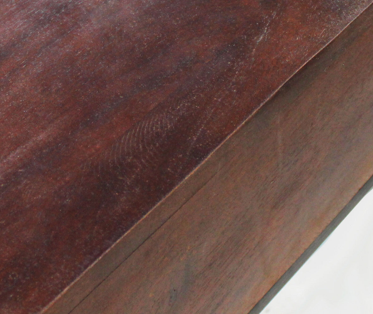 Particolare della superficie superiore in legno liscio marrone della consolle DALY, che mostra le venature naturali del materiale.