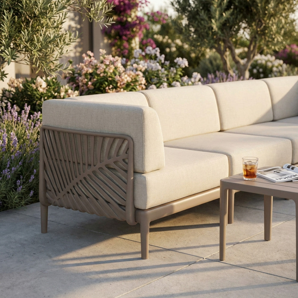 Dettaglio laterale del bracciolo in polipropilene taupe con motivo a foglia, integrato in un divano outdoor beige.