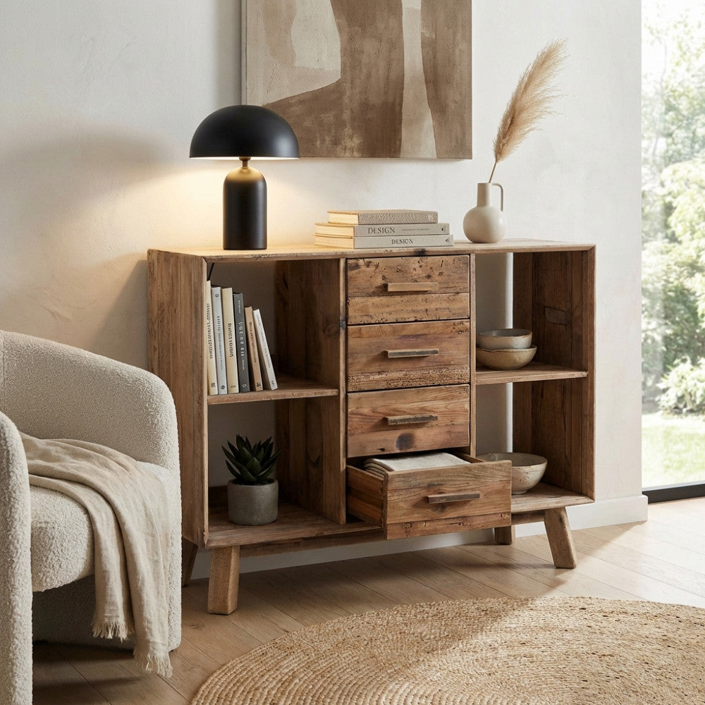 Credenza Adam in pino riciclato marrone ambientata in un soggiorno luminoso con lampada nera e poltrona bouclé.