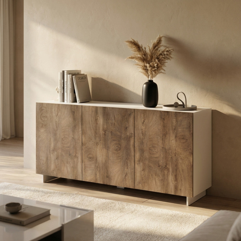 Credenza Carlile in rovere grigio e bianco, ambientata in un soggiorno luminoso con vaso scuro e pampas.