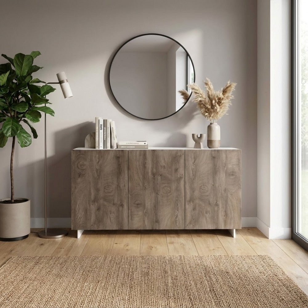 Credenza Carlile in un ingresso raffinato, sormontata da uno specchio rotondo nero e affiancata da una pianta d'appartamento.