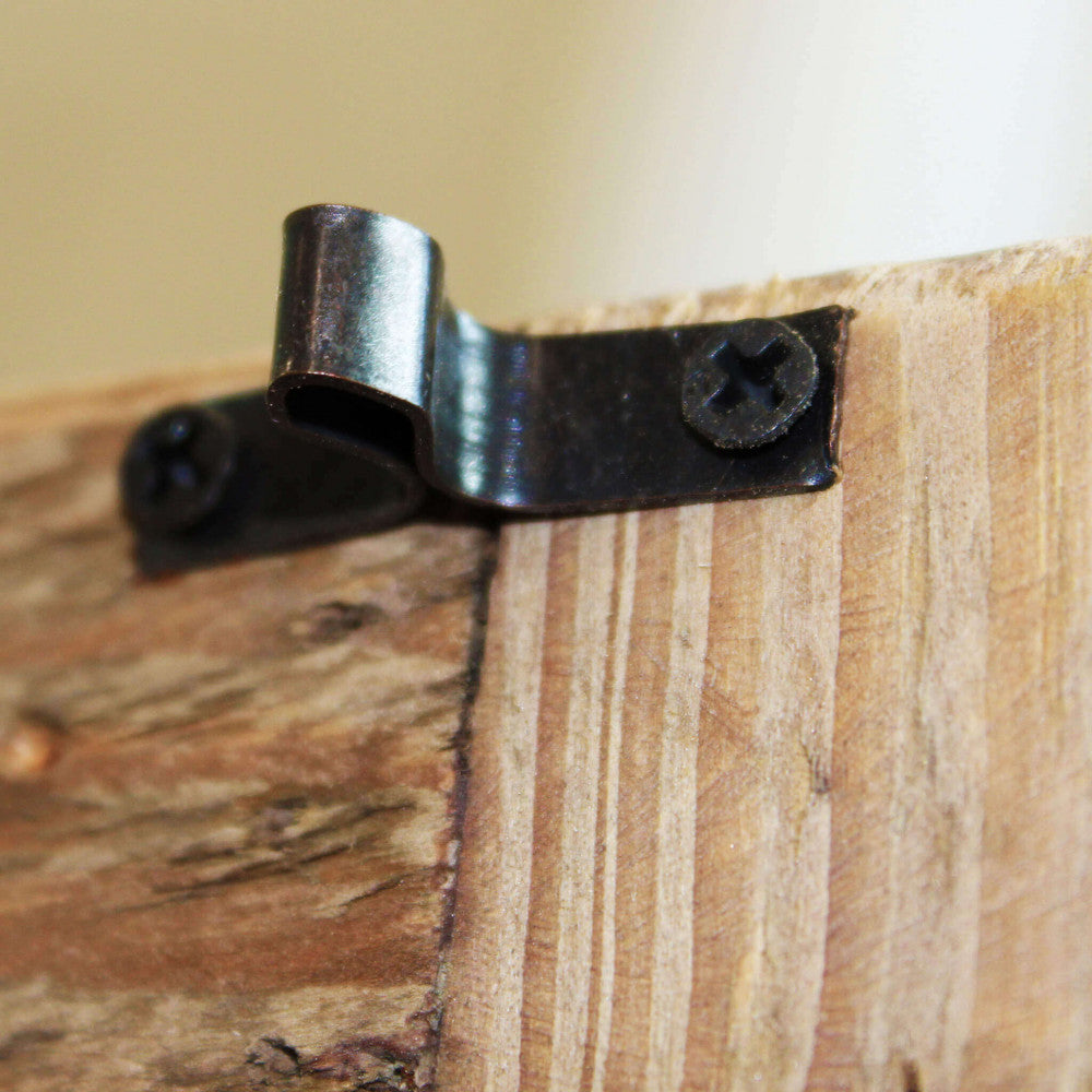Dettaglio ravvicinato della ferramenta in metallo scuro e della texture ruvida del pino riciclato sulla credenza Roland.