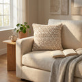 Cuscino Jean in lana e juta illuminato dalla luce naturale su un divano beige.