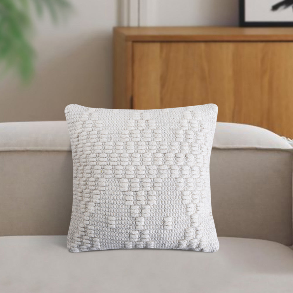 Cuscino Marcel moderno posizionato su un divano minimalista, con luce naturale che ne esalta i dettagli materici.