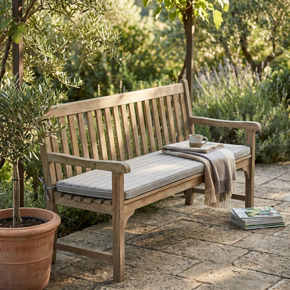 Panca in legno da giardino allestita con il Cuscino Real 110 Righe Tortora, arricchita da una coperta piegata e una tazza.
