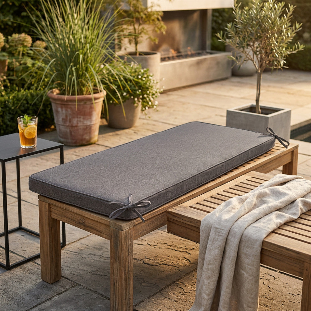 Dettaglio del cuscino Real 150 fissato a una seduta in legno senza schienale in un elegante patio moderno.