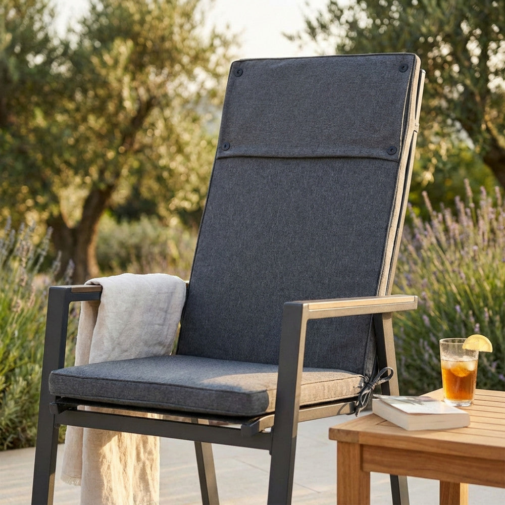 Dettaglio del Cuscino Real Alto grigio scuro su sedia outdoor, che mostra la texture in poliestere e il sistema di fissaggio.