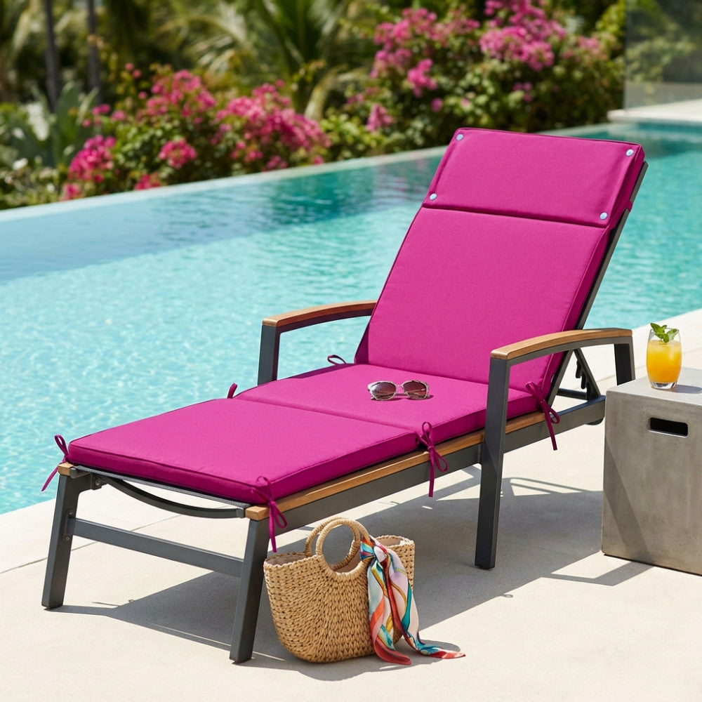 Cuscino lettino Real in poliestere magenta posizionato su una sdraio in legno e metallo a bordo piscina.