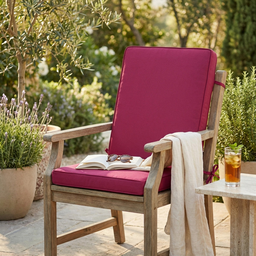 Dettaglio ravvicinato del cuscino outdoor magenta, che evidenzia la texture del poliestere e il comfort della seduta.