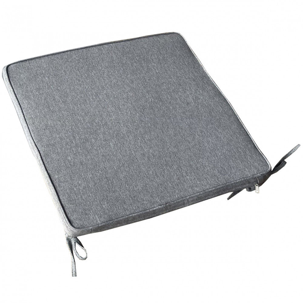 Dettaglio ravvicinato del cuscino quadrato grigio chiaro, che mostra la texture del tessuto, i laccetti e la cerniera.