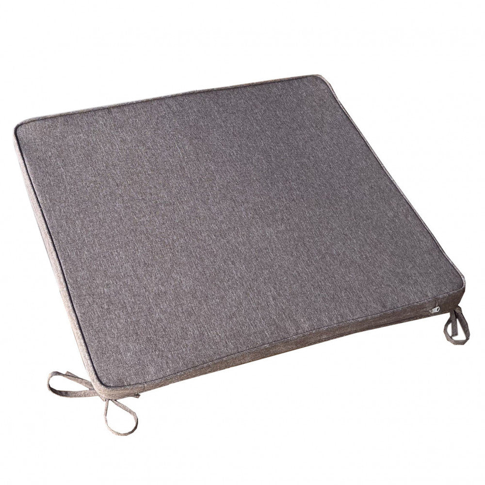 Cuscino quadrato sfoderabile color tortora isolato su sfondo bianco, con cerniera visibile e laccetti per l'ancoraggio alla seduta.
