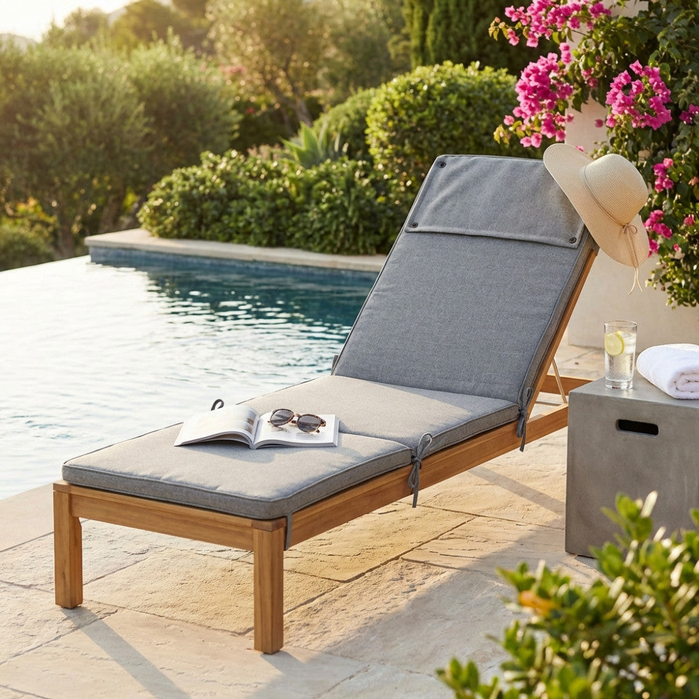 Cuscino Real Steamer grigio chiaro melange posizionato su un lettino in legno a bordo piscina, con cappello di paglia.